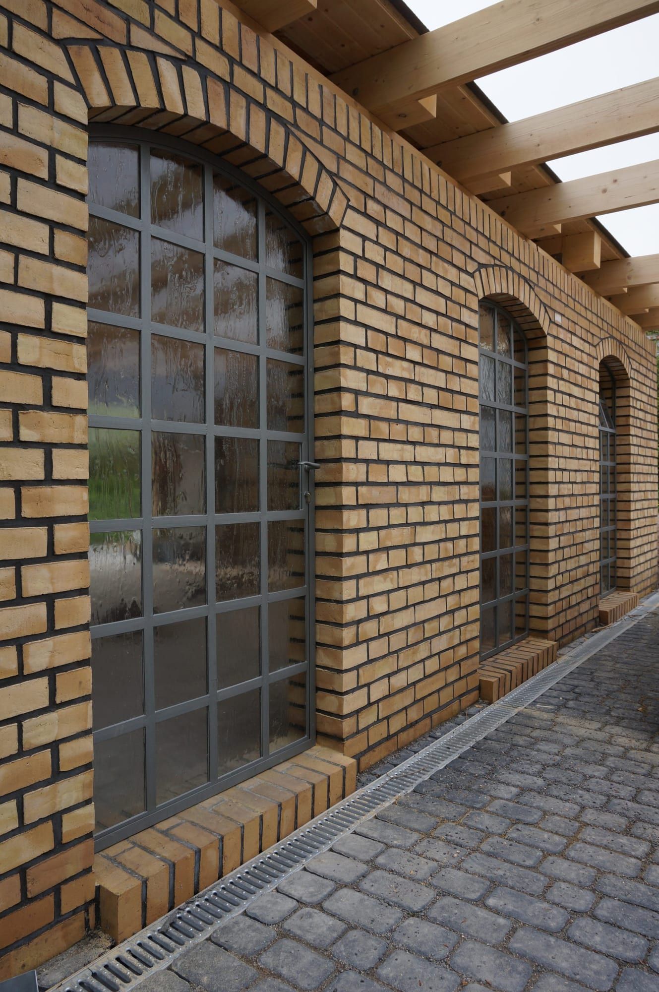 Rundbogenfenster mit Stahlsprossen im Ziegelbau